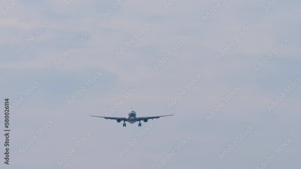 Jet aircraft approaching to land. Airplane flies, blue sky background. Airliner silhouette descending, wide angle view. Travel concept Jet aircraft approaching to land. Airplane flies, blue sky background. Airliner silhouette descending, wide angle view. Travel concept
