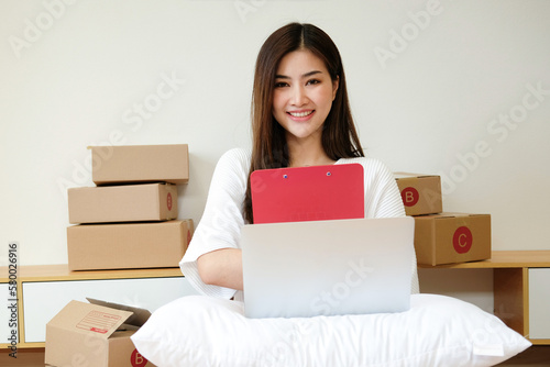 Startup small business owner working at home, woman writing address on parcel box at home for delivery order to customer, Online shopping business.