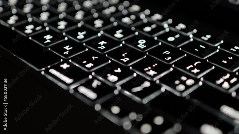 Close up of laptop keyboard backlight, backlit keyboard. Illuminated