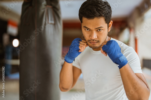 a boxer seriously punching the heavy bags at the boxing studio © Odua Images