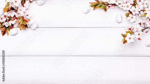 Easter white background. Spring flower border, white happy easter egg on wooden spring background. Easter card. Flat lay.