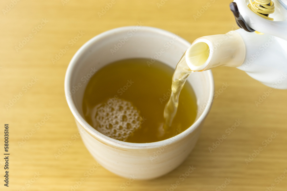 急須で湯呑みに緑茶を入れるイメージ 急須で湯呑みに緑茶を入れるイメージ