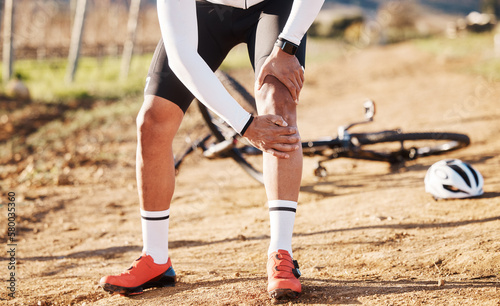 Injury, fitness and man with knee pain while cycling, cramp or inflammation during countryside cardio. Exercise, injured and biker with a sprain after a fall, accident or training for a competition