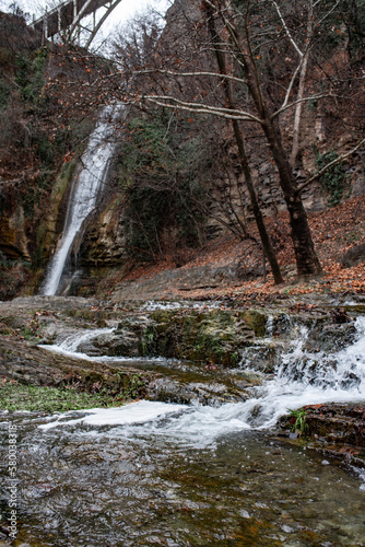 Landscape photo. Waterfall in early spring forest. Nature of Georgia. Vertical photo
