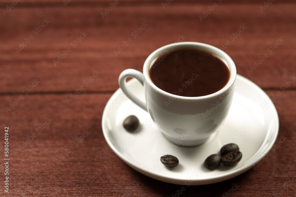 Coffee cup and coffee beans on wooden table. Black background. Coffee cup and coffee beans on wooden table. Black background.