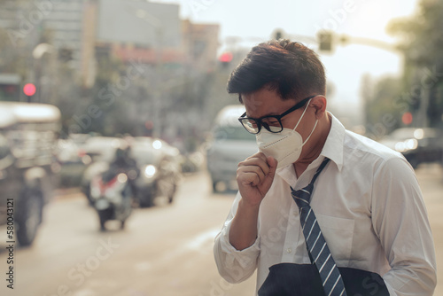 Business man wearing a mask and coughing on the street. Protection against air pollution and dust particles exceeds safety limits.PM2.5 unhealthy air pollution dust smoke in the urban city, PM 2.5