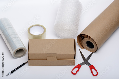 Akcesoria do pakowania paczek w sklepie internetowym - karton, tektura, nożyczki, folia babelkowa, taśma klejąca 