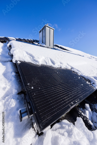 Fototapeta Naklejka Na Ścianę i Meble -  Mit Schnee bedeckte Solarpanele auf dem Dach eines Hauses in Deutschland