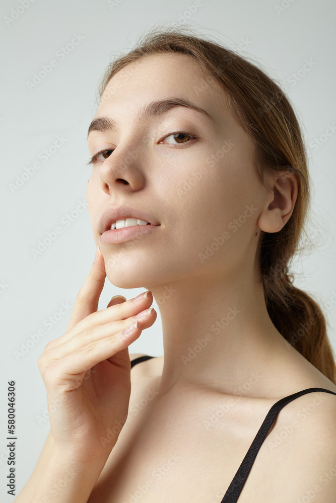 a beautiful woman touches her long neck with her fingers. Beauty theme a beautiful woman touches her long neck with her fingers. Beauty theme