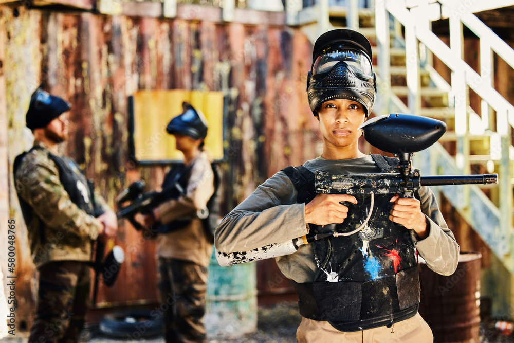 Fototapeta premium Portrait, paintball or woman with gun in game or competition for fitness, exercise or cardio workout. Focus, challenge or serious girl carrying an army weapon or marker for military target training