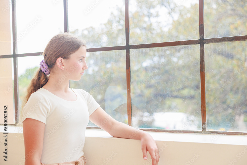 窓辺で外を見るオーストラリア人の可憐な少女