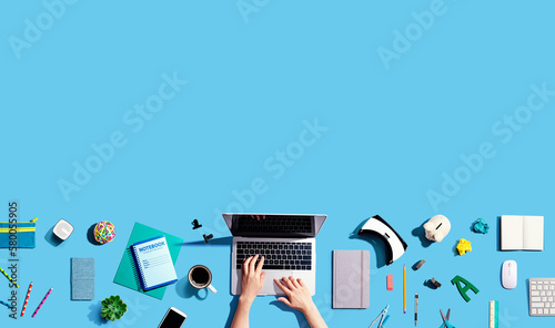 Canvas Print Person using a laptop computer with office supplies - flat la