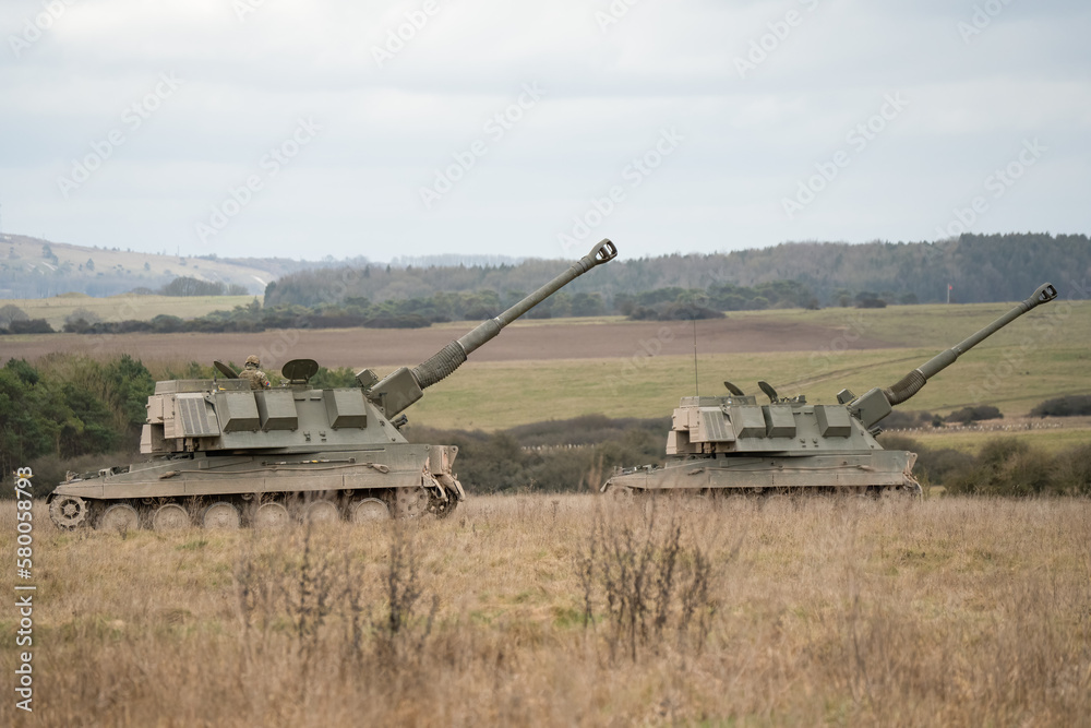 Two British army military AS90 (AS-90 Braveheart Gun Equipment 155mm L131) armoured self-propelled howitzers, guns skywards, on a military exercise, Wilts UK Two British army military AS90 (AS-90 Braveheart Gun Equipment 155mm L131) armoured self-propelled howitzers, guns skywards, on a military exercise, Wilts UK