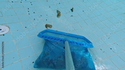 Cleaning the pool with a skimmer net. Underwater POV shooting of the pool. The skimmer net captures fallen leaves and debris from the pool. Pool maintenance process