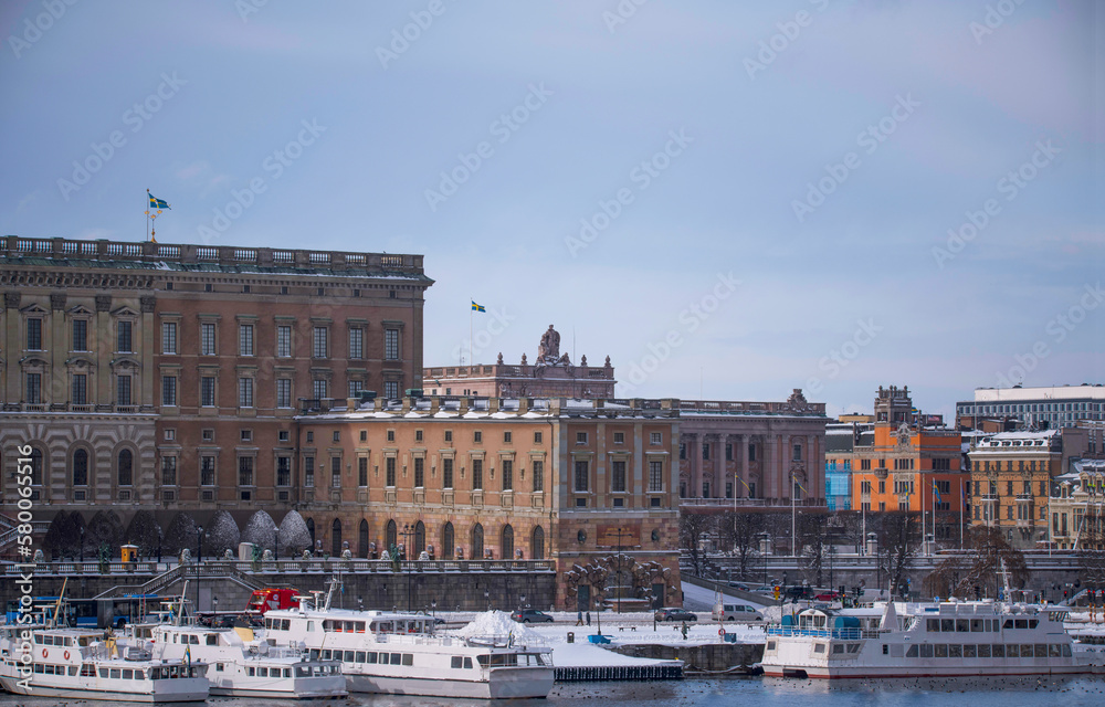 Panorama, the old town Gamla Stan with churches, commuting and tourist boats, a snowy day in Stockholm