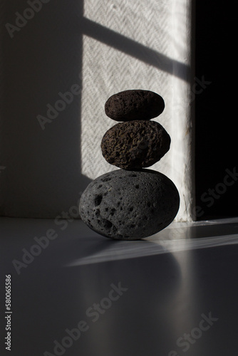 zen three stones pyramid into sun light with shadow