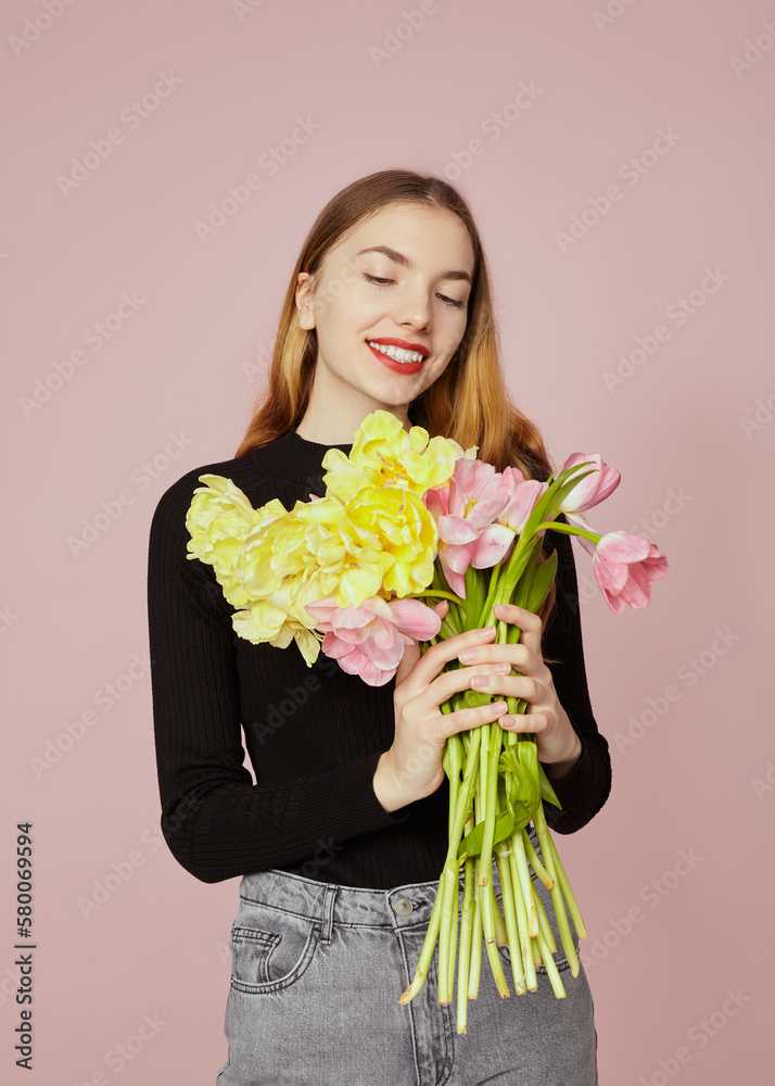 a happy woman with a bouquet of tulips poses on a pink background a happy woman with a bouquet of tulips poses on a pink background