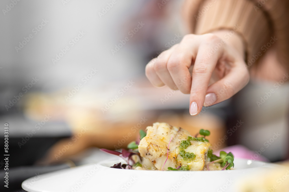 Chef cooks in kitchen restaurant fish, closeup details of preparation of dishes in frying pan and saucepan Chef cooks in kitchen restaurant fish, closeup details of preparation of dishes in frying pan and saucepan