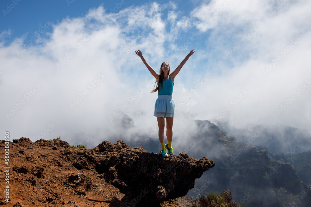 Woman tourist standing on a cloudy mountain peak, Portugal, Madeira. Woman tourist standing on a cloudy mountain peak, Portugal, Madeira.