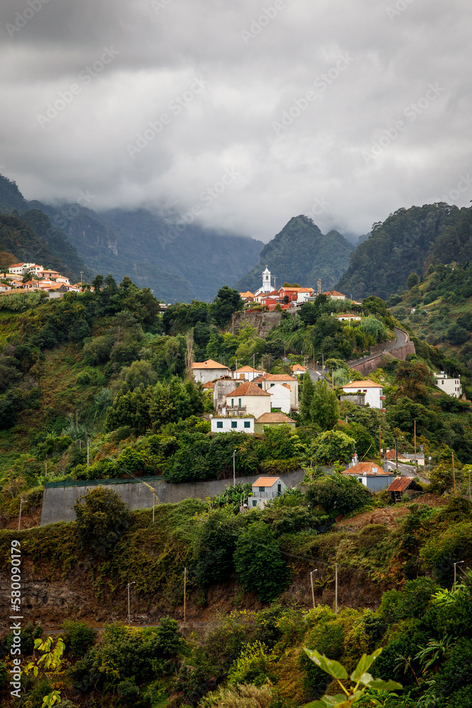 Obraz premium Mountain village among the green island landscape of Madeira.
