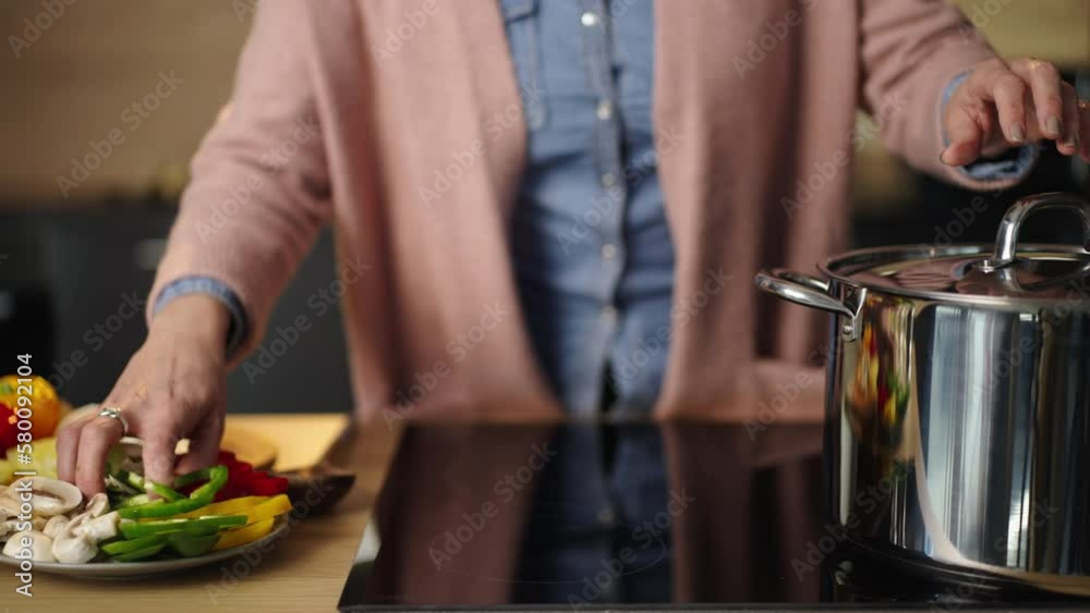 Close-up shot of an urecognized female chef blanching vegetables in a big cooking pot. Slow-motion shot Close-up shot of an urecognized female chef blanching vegetables in a big cooking pot. Slow-motion shot