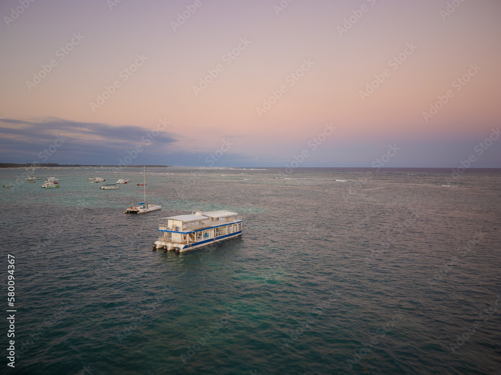 Pleasure boat at sea. Lots of boats. View from above. Twilight. The sky is colored with pink rays of the setting sun. Romance, beautiful seascape, vacation, vacation. Pleasure boat at sea. Lots of boats. View from above. Twilight. The sky is colored with pink rays of the setting sun. Romance, beautiful seascape, vacation, vacation.