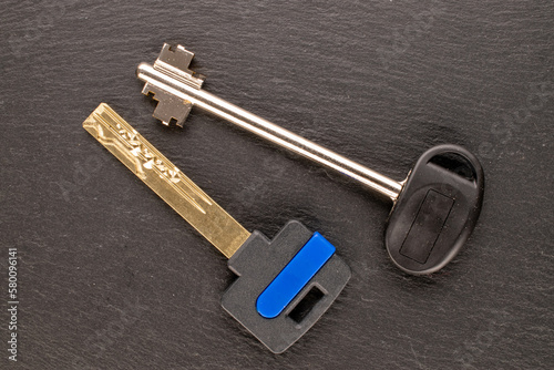 Two metal keys from a door lock on slate stone, macro, top view. © Oleksandr