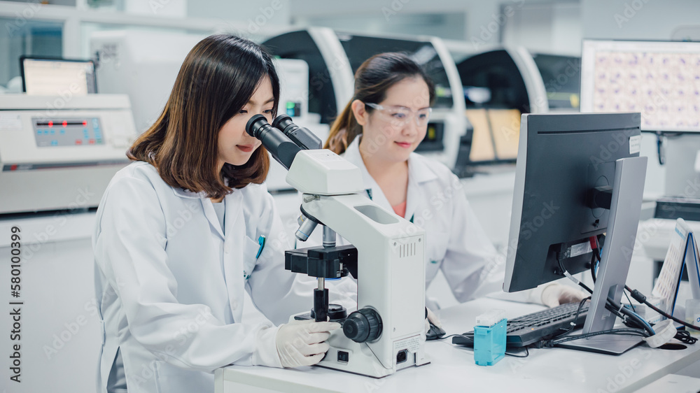 Team of medical research scientists collectively working on new research knowledge of sciences with microscope in laboratory. Medical technology and biochemical in pharmaceutical concept. Team of medical research scientists collectively working on new research knowledge of sciences with microscope in laboratory. Medical technology and biochemical in pharmaceutical concept.