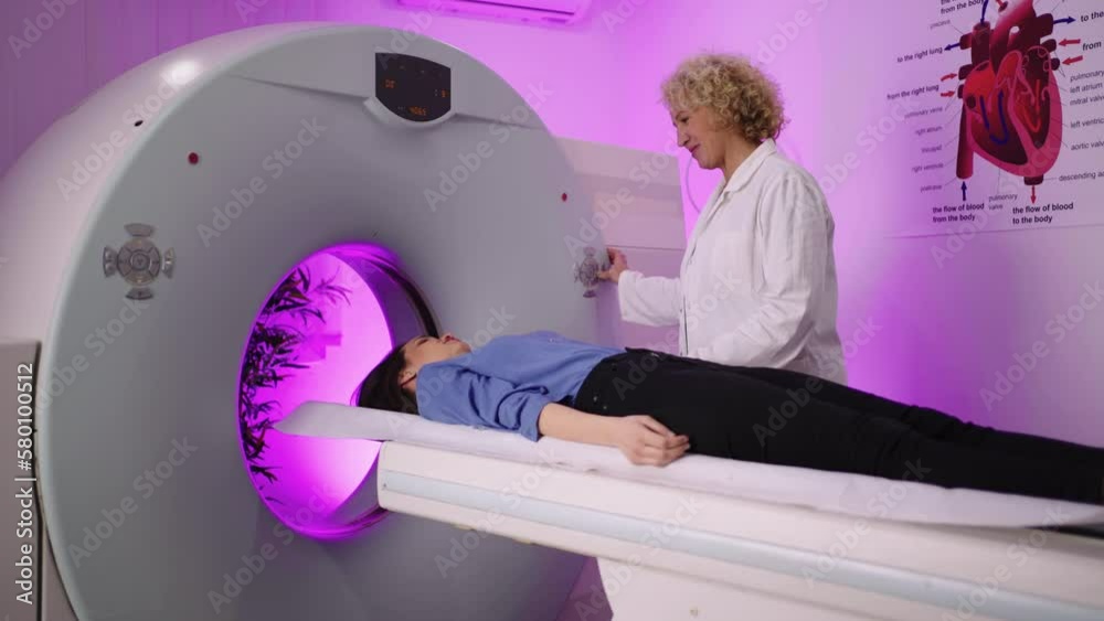 In Medical Laboratory Radiologist Controls MRI Or CT Scan With Female in-medical-laboratory-radiologist-controls-mri-or-ct-scan-with-female