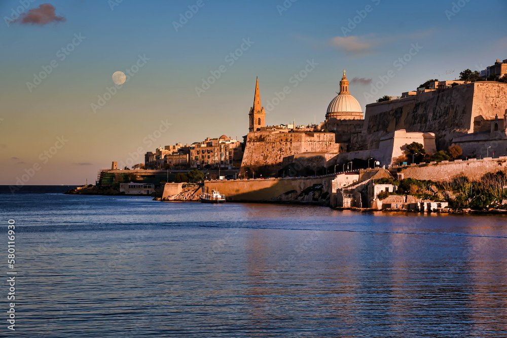 View on Malta walls during sunset with visible moon in the sky. 