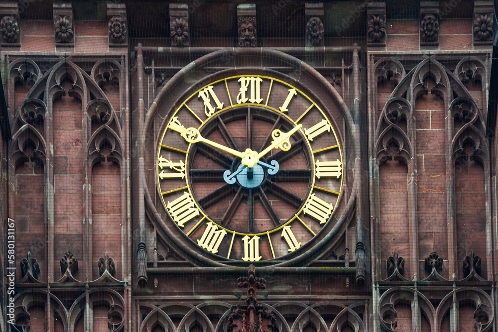 A gilded clock face on an ancient tower A gilded clock face on an ancient tower