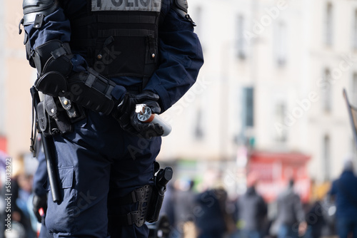 Un policier tenant une bombe lacrymogène