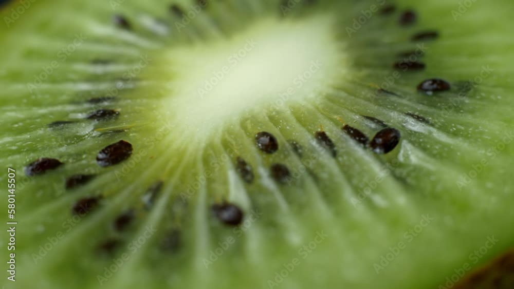 macro shot rotating slice of sliced kiwi. Extreme close-up of the texture of a cut kiwi slice. Fresh juicy fruit. macro shot rotating slice of sliced kiwi. Extreme close-up of the texture of a cut kiwi slice. Fresh juicy fruit.