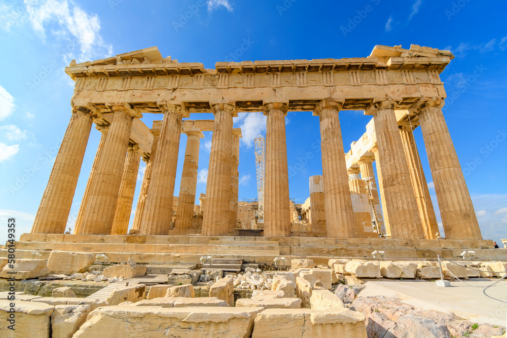 Fototapeta premium View of the ancient Greek Parthenon on Acropolis Hill in Athens, Greece with a blue sky behind. 
