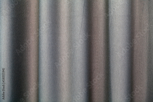 Fragment of steel-colored vertical textile curtains. Selective focus.