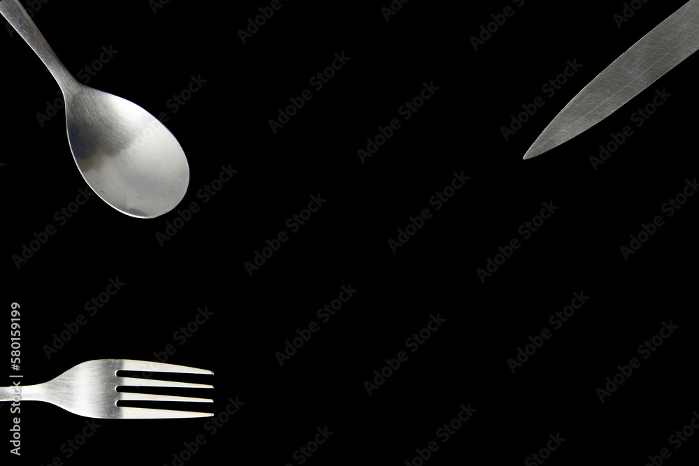 Elegant Cutlery Set of fork, spoon and knife on Black Background for
