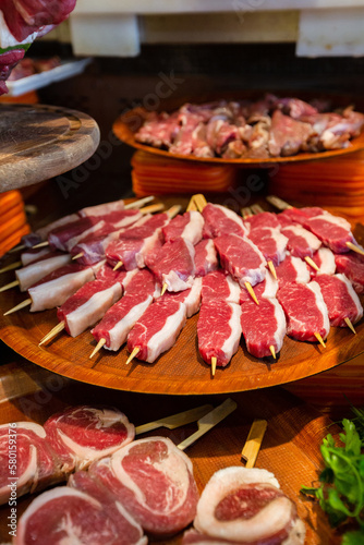 Meat department, showcase with variety of meat in different cuts. Inside an supermarket. Different types of fresh meat arranged in an orderly manner. 