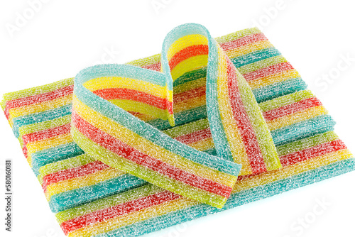 Rainbow sour jelly candy strip in sugar sprinkles isolated over white background with. Close-up