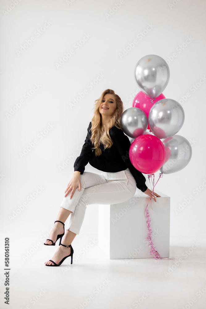 Smiling blonde woman with balloons isolated on white. Girl with braces. Orthodontics treatment.
