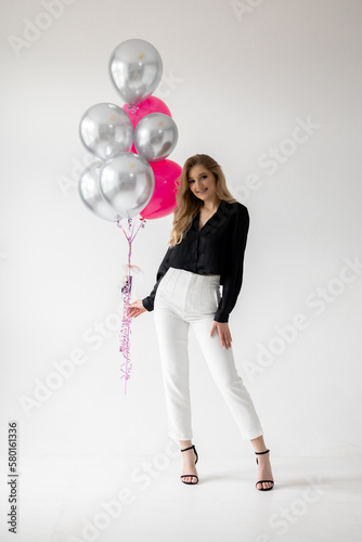 Smiling blonde woman with balloons isolated on white. Girl with braces. Orthodontics treatment. © sorin