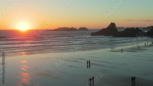A drone shot of Chesterman beach at sunset and people silhouettes walking around photo