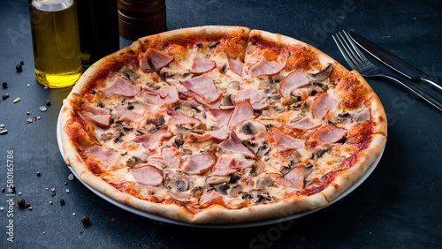Italian cuisine pizza with ham, mushrooms, cheese and tomato sauce.