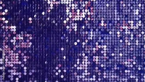 Abstract background with flickering and glittering silver colorful metallic particles or sequins on the wall.