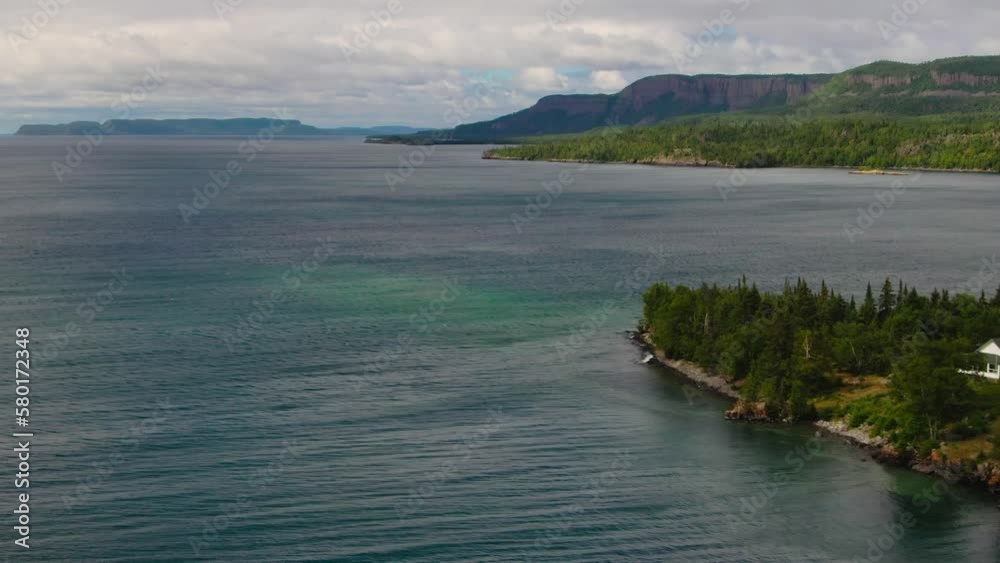 Aerial view of blue water Lake Superior with green Canadian coastline Sleeping Giant Silver Islet Evergreen Trees Mountain Cliffs in background Aerial view of blue water Lake Superior with green Canadian coastline Sleeping Giant Silver Islet Evergreen Trees Mountain Cliffs in background