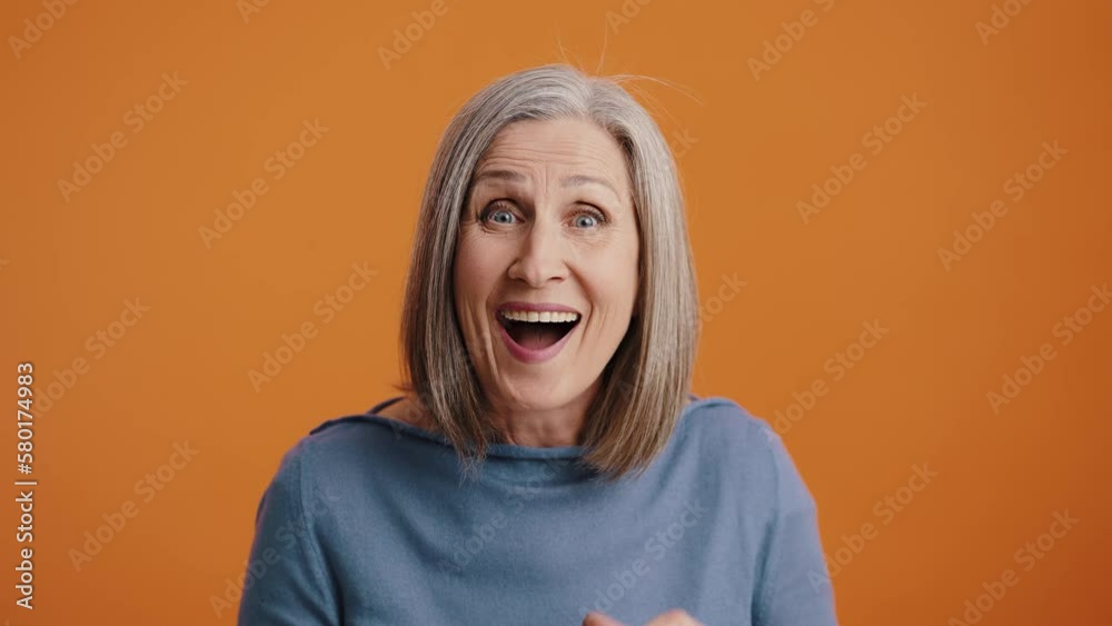 Senior woman rejoices clapping hands and waving fists Senior woman rejoices clapping hands and waving fists