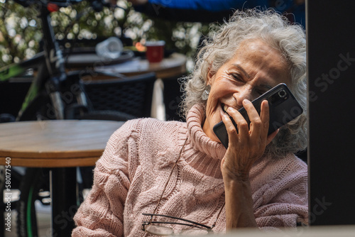 Grey-haired Woman on the Phone in Cafe effortlessly Connected