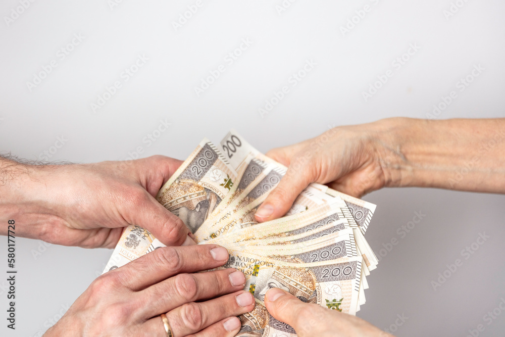Dłonie mężczyzny i kobiety wymieniających się pieniędzmi. Banknoty na białym tle. Liczenie pieniędzy. - obrazy, fototapety, plakaty 