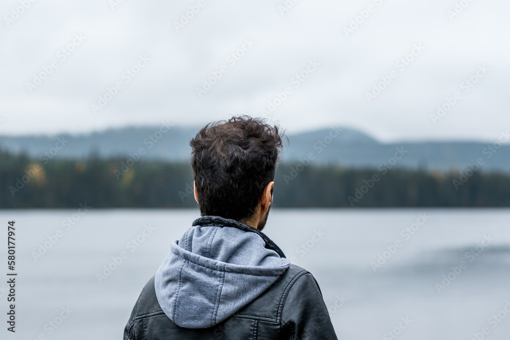 Young man looking out over lake