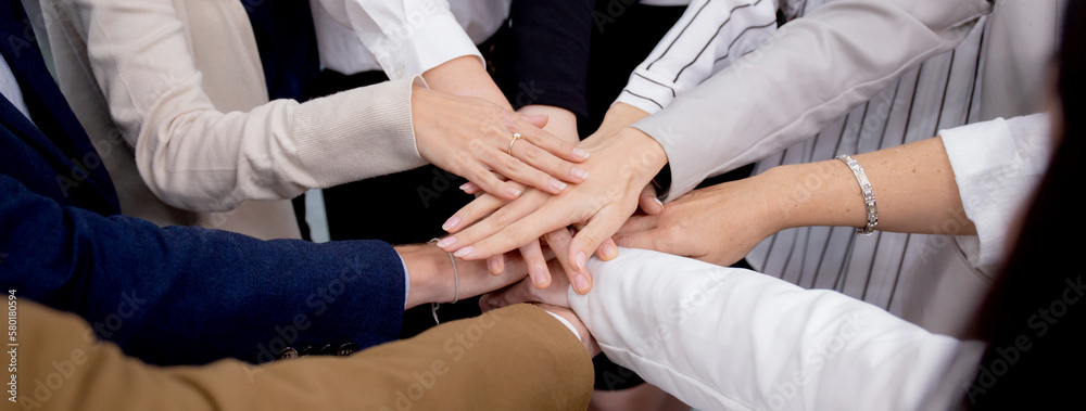 Group of business team harmonious with man and woman joining hands stack together in enterprise for victory and success, teamwork of partnership with meeting and cheering for achievement.