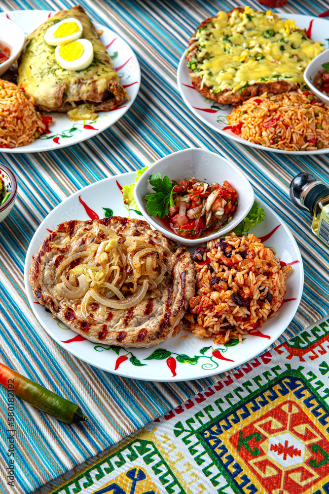 Traditional mexican food. Grilled pork tenderloin with spicy rice and salsa sauce. Colorful Food Table Celebration Delicious Party Meal Concept. 